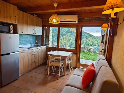 uma cozinha com um sofá e uma mesa com vista em La Cabanya de Can Menut em Molló