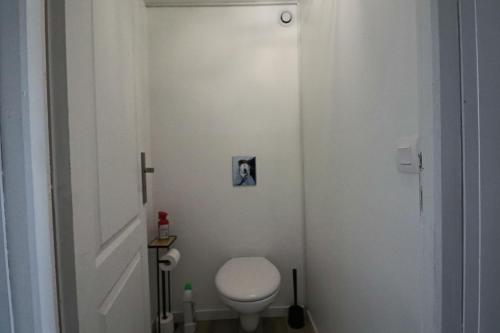 bagno con servizi igienici bianchi in camera di Les Chatons - Résidence Guillaume Lacoste a La Bourboule