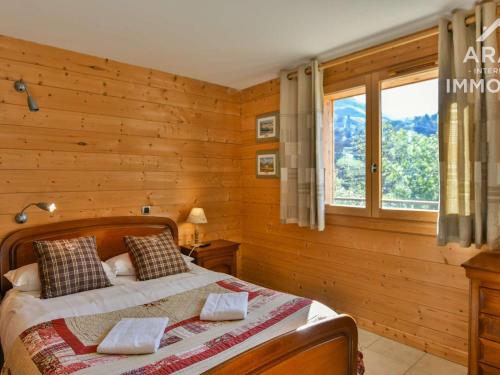 ル・グラン・ボルナンにあるChalet Le Grand-Bornand, 10 pièces, 18 personnes - FR-1-391-29のベッドルーム1室(木製の壁と窓のあるベッド1台付)