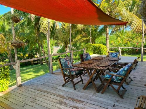 einen Holztisch und Stühle auf einer Holzterrasse in der Unterkunft Ebony beach in Vilankulo