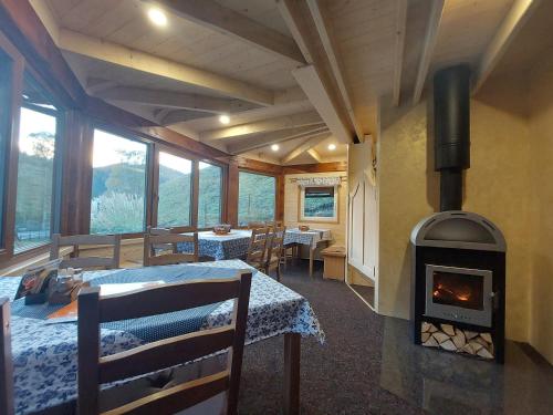 a room with a fireplace and a dining room with tables at U Veselé lišky in Hutisko