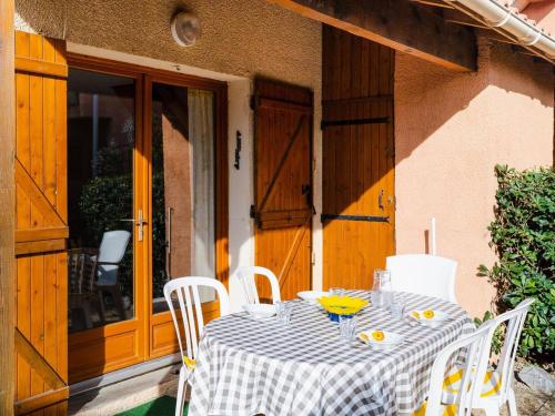 une table avec un chiffon de table en damier sur une terrasse couverte dans l'établissement Charmant pavillon 3 pièces à Narbonne-Plage, grande terrasse, parking, WIFI, 4 pers, plage à proximité - FR-1-409-96, à Narbonne-Plage