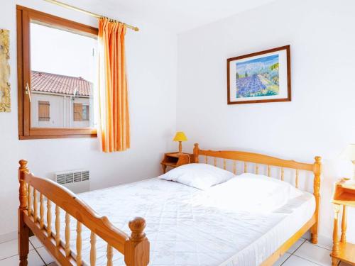une chambre avec un lit en bois et une fenêtre dans l'établissement Charmant pavillon 3 pièces à Narbonne-Plage, grande terrasse, parking, WIFI, 4 pers, plage à proximité - FR-1-409-96, à Narbonne-Plage