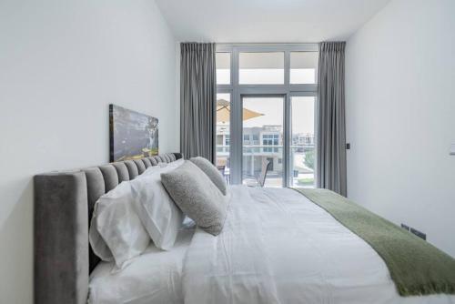 sypialnia z dużym łóżkiem i dużym oknem w obiekcie Amal villa by escape time w Dubaju