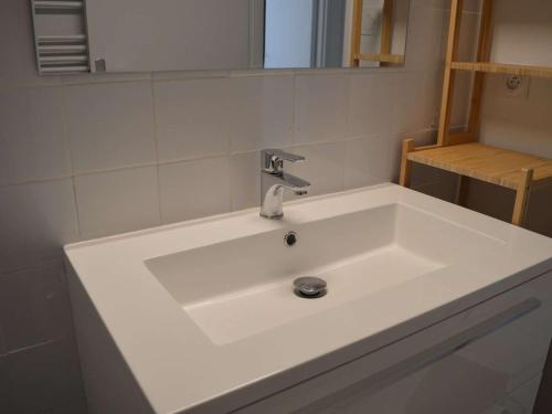 un lavabo blanc dans une salle de bain avec un miroir dans l'établissement Appartement 3 pièces rénové, 6 couchages, au cœur de Banyuls-sur-Mer - FR-1-225C-49, à Banyuls-sur-Mer