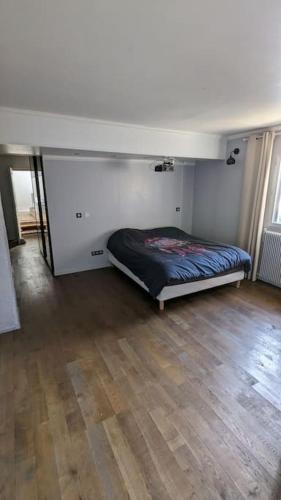 - une chambre avec un lit dans une pièce dotée de parquet dans l'établissement Maison de 5 chambres de 195 m carrés près d'Orly., à Savigny-sur-Orge