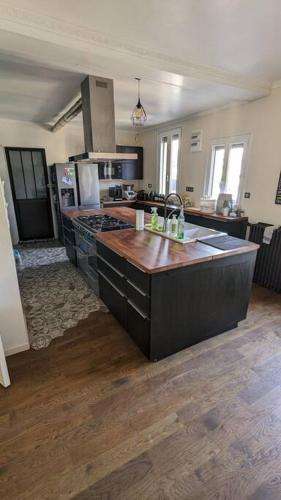 - une cuisine avec un îlot au milieu d'une pièce dans l'établissement Maison de 5 chambres de 195 m carrés près d'Orly., à Savigny-sur-Orge