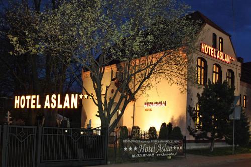 um edifício asiático de hotel com luzes acesas à noite em Hotel Aslan em Tarnowskie Góry