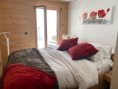 a bedroom with a bed with red and white pillows at B&B rooms within a modern family chalet with direct access to ski area in Verbier in Verbier