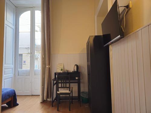 a kitchen with a black refrigerator and a table with a chair at Giardino Siciliano B&B in Catania