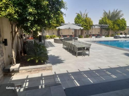 a patio with a table and chairs next to a pool at Taj Villa deadsea - Entire Villa with sea view in Sowayma