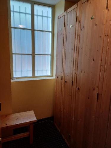 Habitación con armario de madera y ventana. en Studio hyper centre lumineux et fonctionnel Luchon, en Luchon