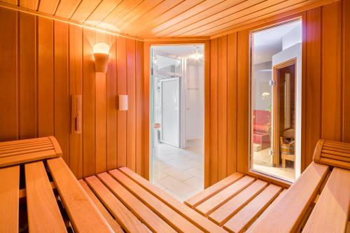 a wooden room with a bench and a window at Inselhotel Langeoog in Langeoog
