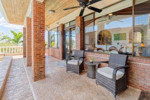 an outdoor patio with wicker chairs and a brick wall at Luxury Flamingo villa with outdoor bar - pool and magnificent views in Playa Flamingo