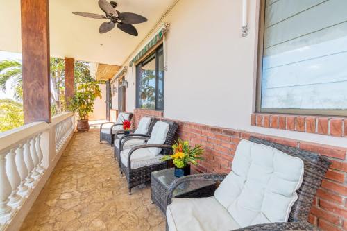 a porch with chairs and a ceiling fan at Luxury Flamingo villa with outdoor bar - pool and magnificent views in Playa Flamingo