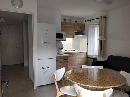 uma sala de estar com mesa e cadeiras e uma cozinha em St Raphaël 37m2, piscine, wifi, commerces mer 5mn à pieds em Saint-Raphaël