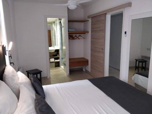- une chambre avec un grand lit blanc et un couloir dans l'établissement St Raphaël 37m2, piscine, wifi, commerces mer 5mn à pieds, à Saint-Raphaël