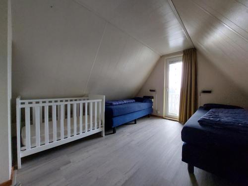 a attic room with two beds and a crib at De Vecht, 124 - centraal gelegen aan vijver in Gramsbergen