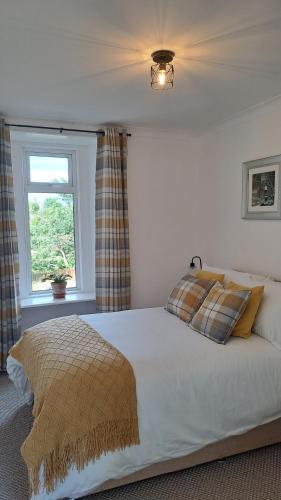 a bedroom with a large bed with a window at Riverview Cottage in Halkirk