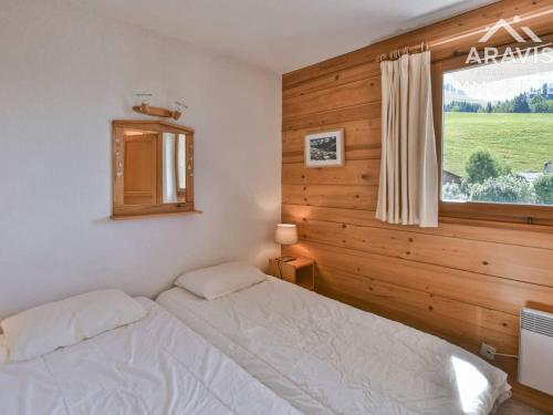 a bedroom with a white bed and a window at Appartement Le Grand-Bornand, 4 pièces, 6 personnes - FR-1-391-144 in Le Grand-Bornand
