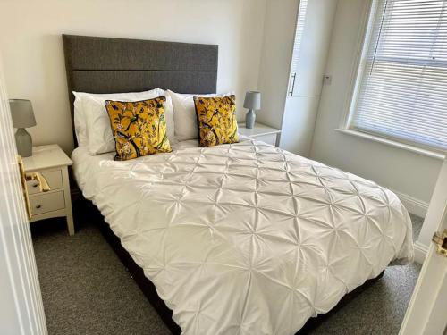 a bedroom with a large white bed with two pillows at House by the Sea, Worthing in Worthing