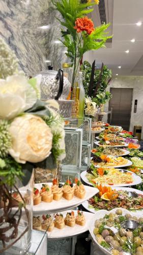 a buffet line with plates of food on display at Maysan Al Mashaer Hotel in Makkah