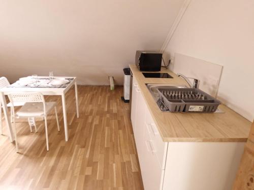una pequeña cocina con fregadero y mesa en Superbe maison au calme refaite à neuf, en Bigonville