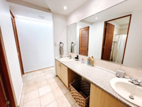a bathroom with two sinks and a large mirror at Oasis Village Spacious Apt W/ Ocean View For 9 in Rio Grande