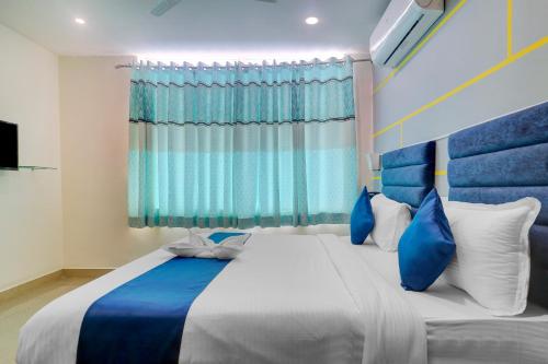 una camera da letto con un grande letto con cuscini blu e bianchi di Hotel Jkc Grand a Hyderabad