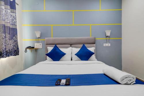 una camera da letto con un letto con cuscini blu e bianchi di Hotel Jkc Grand a Hyderabad