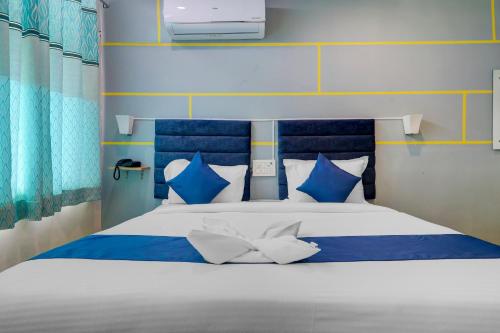 un letto blu e bianco con cuscini bianchi e blu di Hotel Jkc Grand a Hyderabad