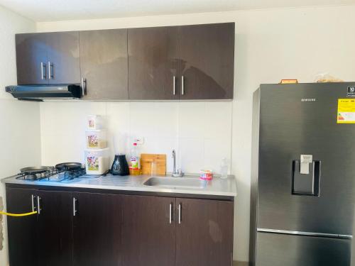 a kitchen with a sink and a refrigerator at Habitacion disponible in Valledupar