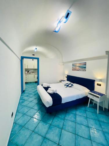 a bedroom with a bed with a blue floor at Eden Holiday in Minori