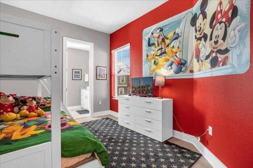 um quarto para crianças com paredes vermelhas e uma parede vermelha em Magical Vacation Home 3 min from Disney em Orlando