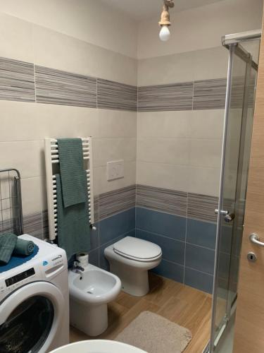 a bathroom with a toilet and a sink and a washing machine at La Casetta sul mare - Alloggio turistico in Fiumicino