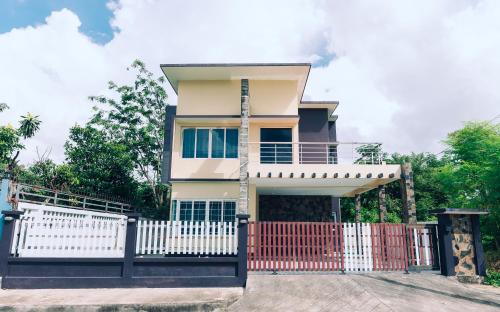 une maison avec un portail rouge et une clôture blanche dans l'établissement AABAN House 03, à Hat Yai
