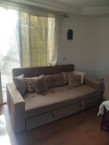 a living room with a couch with pillows on it at Tiba soliman plage in Nabeul