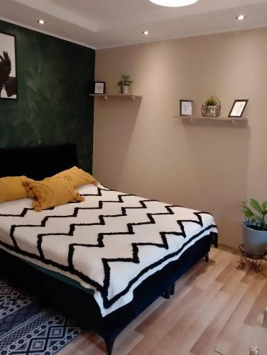 a bedroom with a black and white comforter on a bed at Apartament Zibi in Zamość