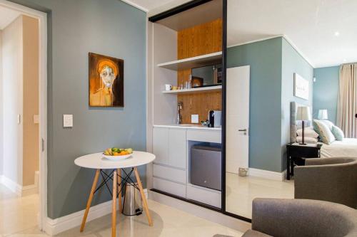 a living room with a table and a kitchen at The View, Studio in Hermanus