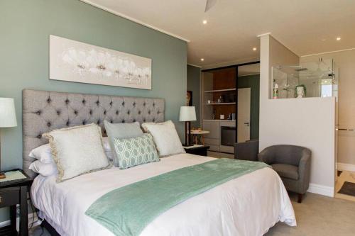 a bedroom with a large bed and a chair at The View, Studio in Hermanus