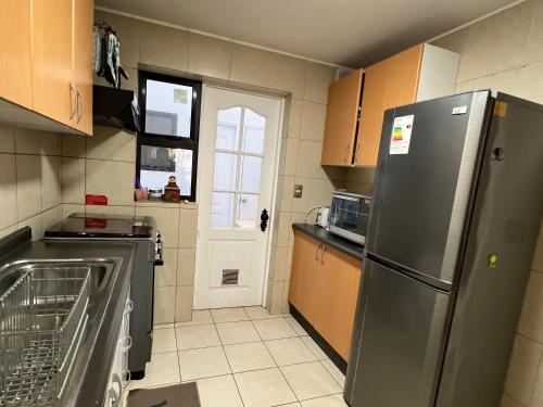 a kitchen with a stainless steel refrigerator and a door at Excelente casa en Pucón in Pucón