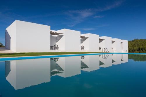 a row of white buildings on a body of water at Monte das Texugueiras in Texugueira