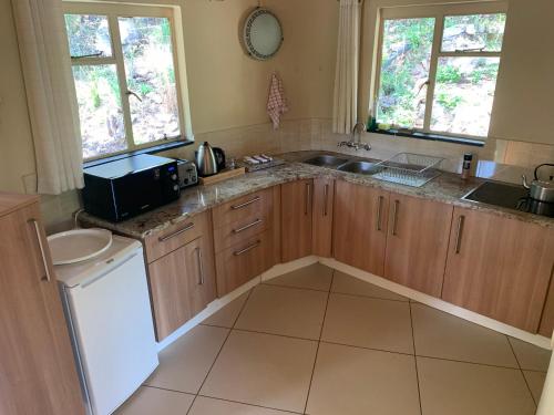 a kitchen with a sink and a counter top at Forestiva Farm - River Cottage in Centurion