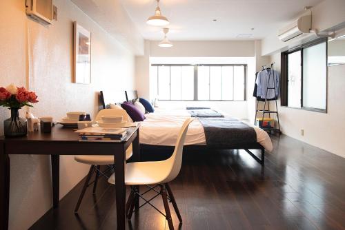 a bedroom with a bed and a table and a desk at #2 3stops to Shinjuku station stylish spacious studio apartment in Tokyo