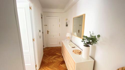 Habitación blanca con mesa y espejo. en Apartamento Las Rozas centro con Parking incluido en Las Rozas de Madrid