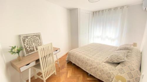 een kleine slaapkamer met een bed en een bureau bij Apartamento Las Rozas centro con Parking incluido in Las Rozas de Madrid