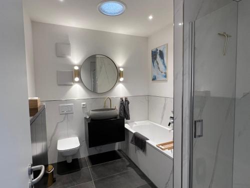 a bathroom with a sink toilet and a mirror at Modernes Appartement an der Krämerbrücke, Altstadt in Erfurt