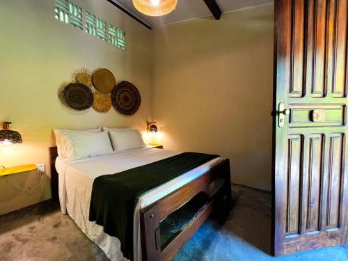 a bedroom with a bed in a room with a door at Pousada Moreré in Ilha de Boipeba