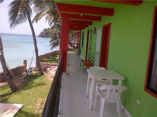a room with a table and chairs and the ocean at Cabañas Mister Mac in Providencia