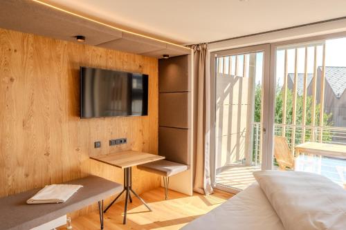 ein Schlafzimmer mit einem Bett und einem TV an der Wand in der Unterkunft Aparthotel Parsberg GreenDesign in Parsberg